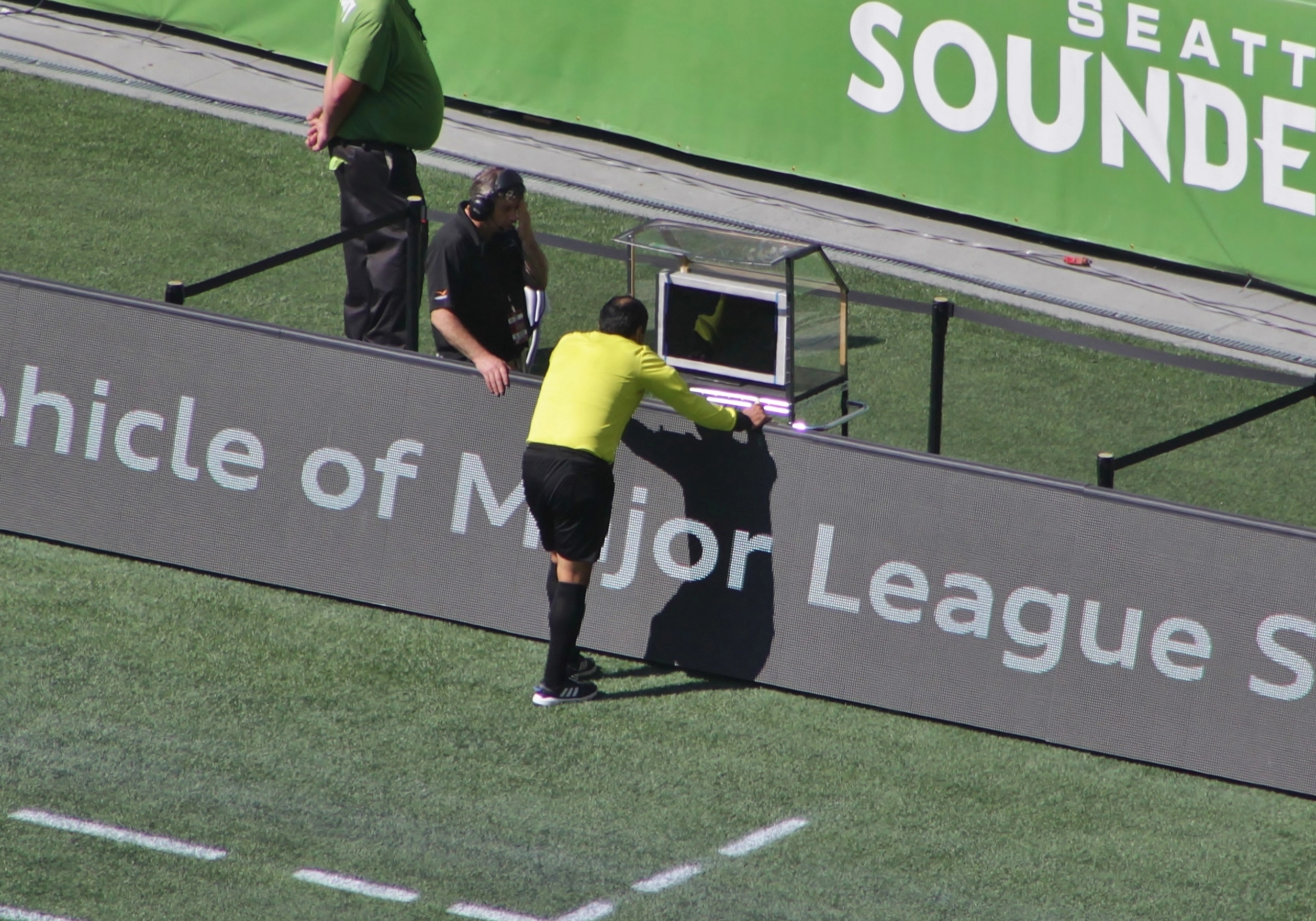 Un arbitro consulta il monitor del Video Assistant Referee a bordo campo